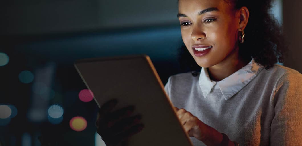 Woman smiling, using a tablet, and posing for a photo